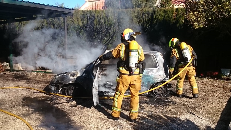 Bombers sufocant l'incendi del cotxe