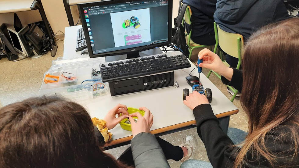 Alumnes manipulant un robot // Foto: SJXXIII