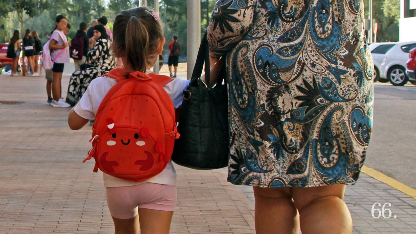 Niña acompañada por una familiar el primer día de colegio
