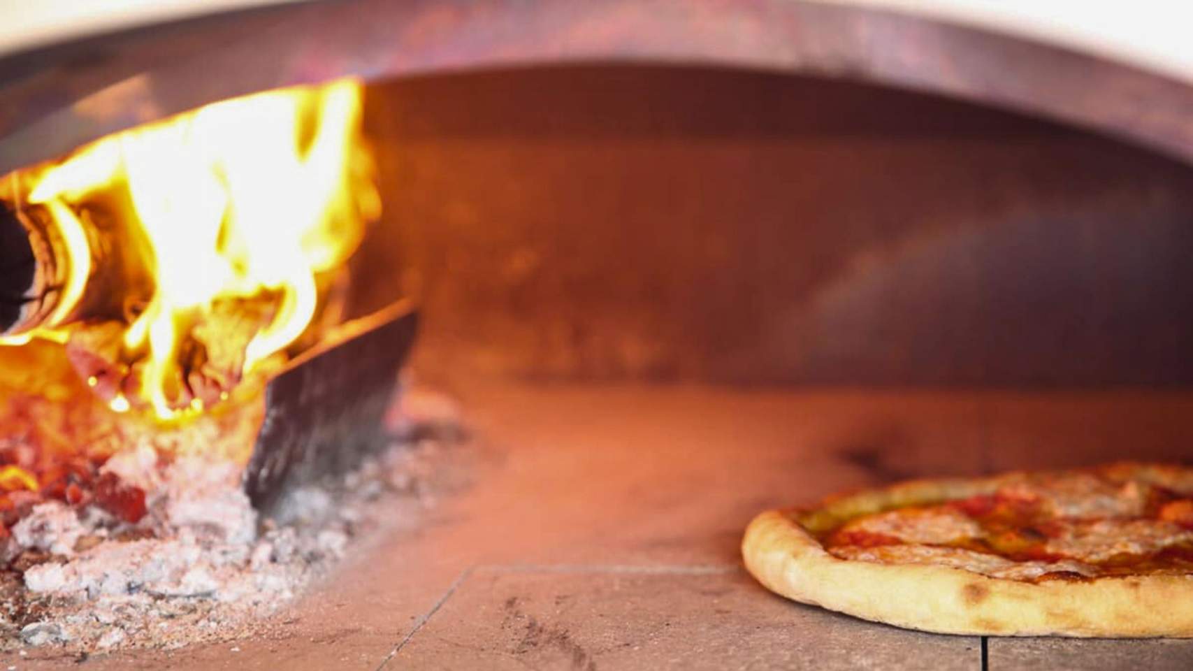 Horno de leña cocinando una pizza