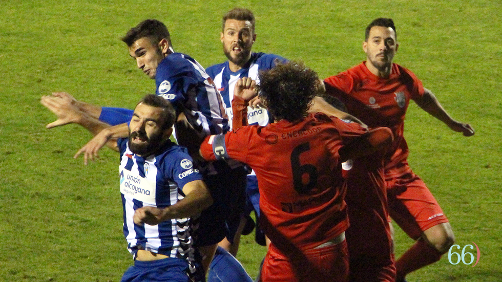 Tres jugadores del Alcoyano intentan el remate en el área del Crevillente