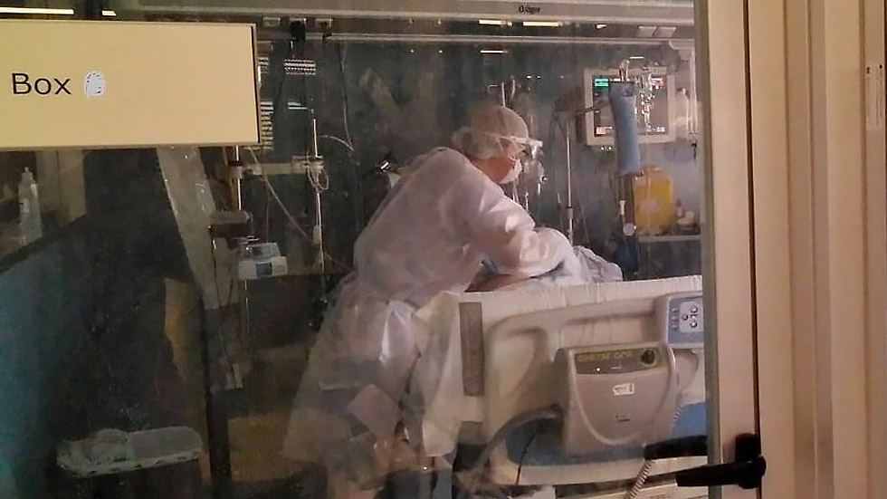 Un sanitario atiende a un enfermo de covid-19 en la UCI del hospital Virgen de los Lirios / Foto Departamento de Salud