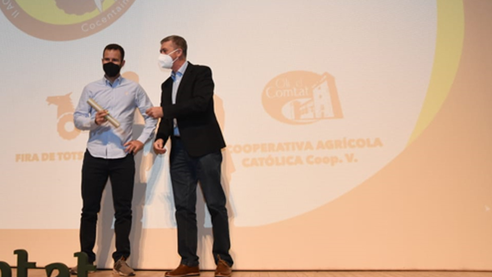 Pau Ferrando, productor d'Eco Travadell, arreplega el premi de mans del conseller Rafa Climent